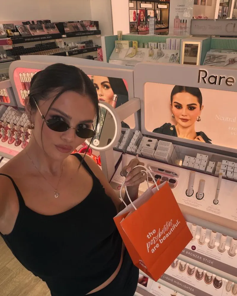 Selena Gomez wearing a center-parted bun with face-framing pieces at Ulta