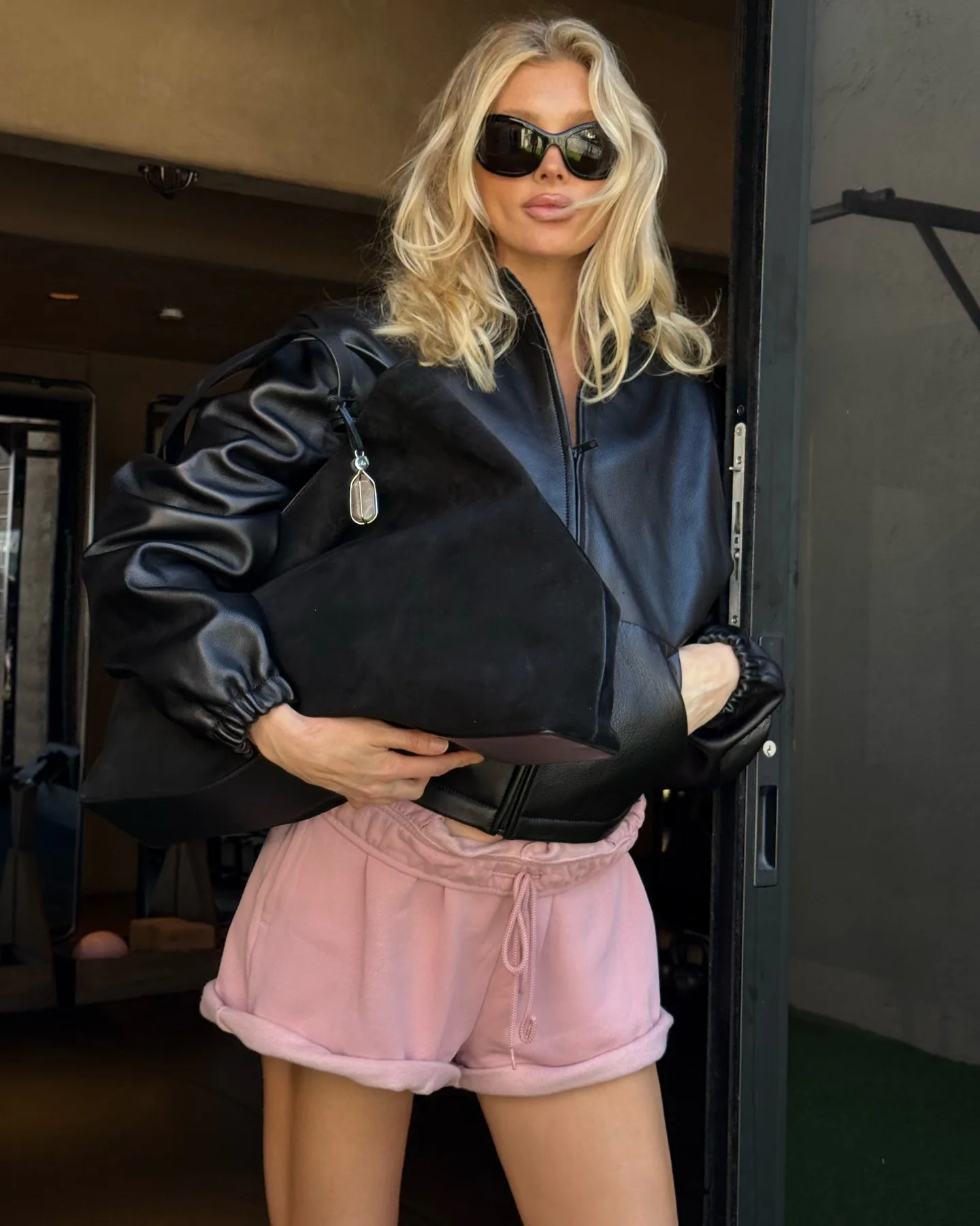 Elsa Hosk wears a leather jacket and sweat shorts to the gym. 