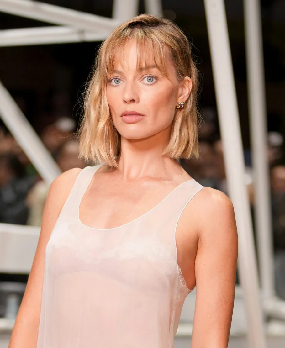 Margot Robbie at the Chanel fashion show before wearing a tweed jacket.