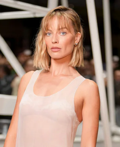 Margot Robbie at the Chanel fashion show before wearing a tweed jacket.