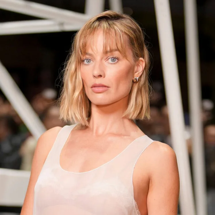 Margot Robbie at the Chanel fashion show before wearing a tweed jacket.