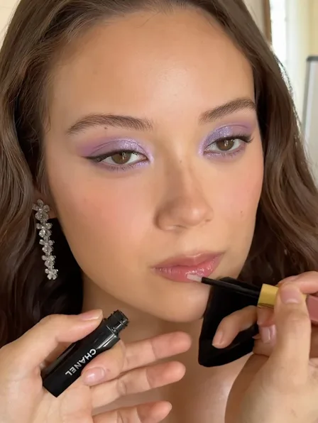 Laufey getting her makeup done, with sparkly lilac eyeshadow on her lids