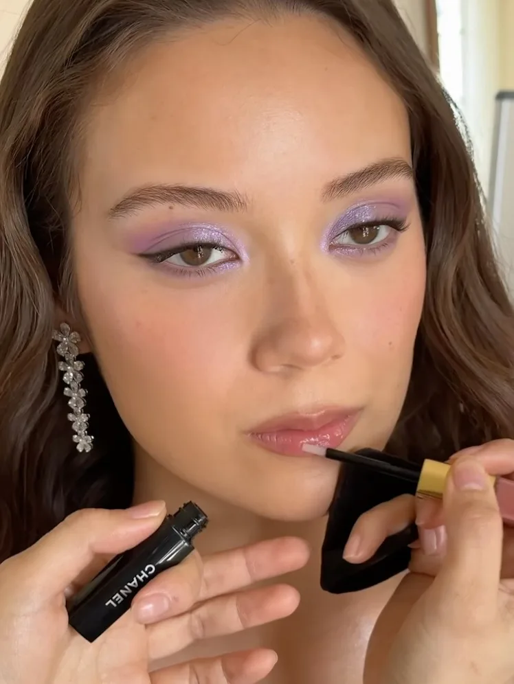 Laufey getting her makeup done, with sparkly lilac eyeshadow on her lids