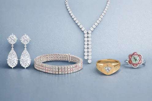 Collection of diamond jewelry including drop earrings, gold ring, floral gemstone ring, tennis brace...