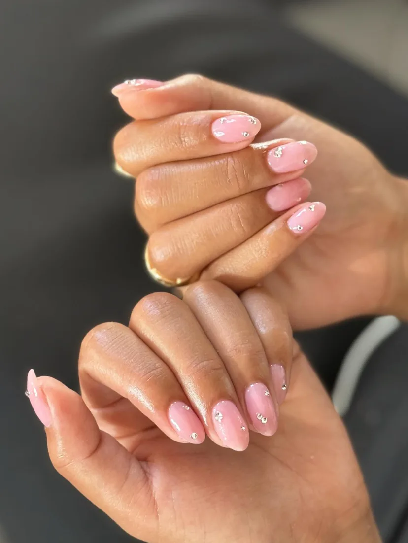 Close up of Olivia Dean's bedazzled neutral manicure