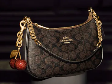 The Teri bag in a signature print, with a cherry charm.