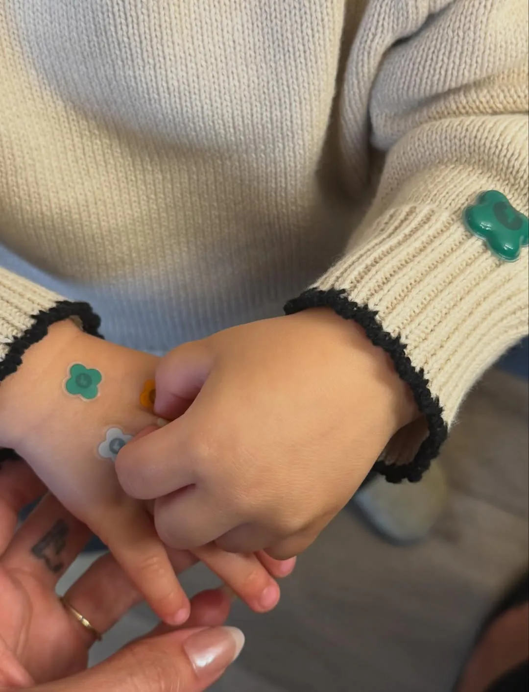 Hailey Bieber, holding her son's hand, her French tip chrome mani visible