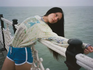 A model wearing Adrian Cashmere by the sea