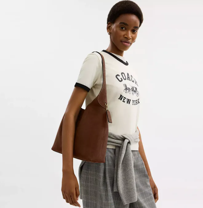 Young woman carrying a Coach Brooklyn bag.