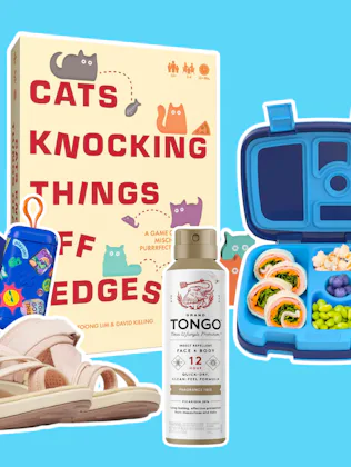 Flat lay of assorted items on blue background: children's sandals, sticker sheets, a boxed book titl...