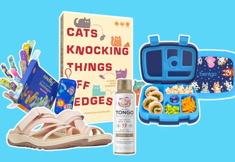 Flat lay of assorted items on blue background: children's sandals, sticker sheets, a boxed book titl...