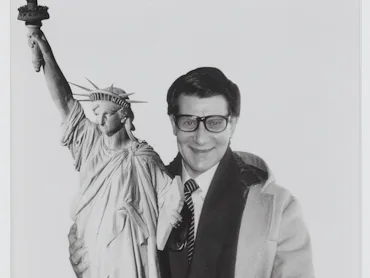 Yves Saint Laurent carrying a reproduction of the Statue of Liberty, New York, 1983