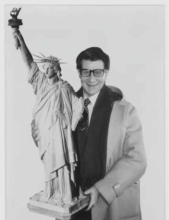 Yves Saint Laurent carrying a reproduction of the Statue of Liberty, New York, 1983