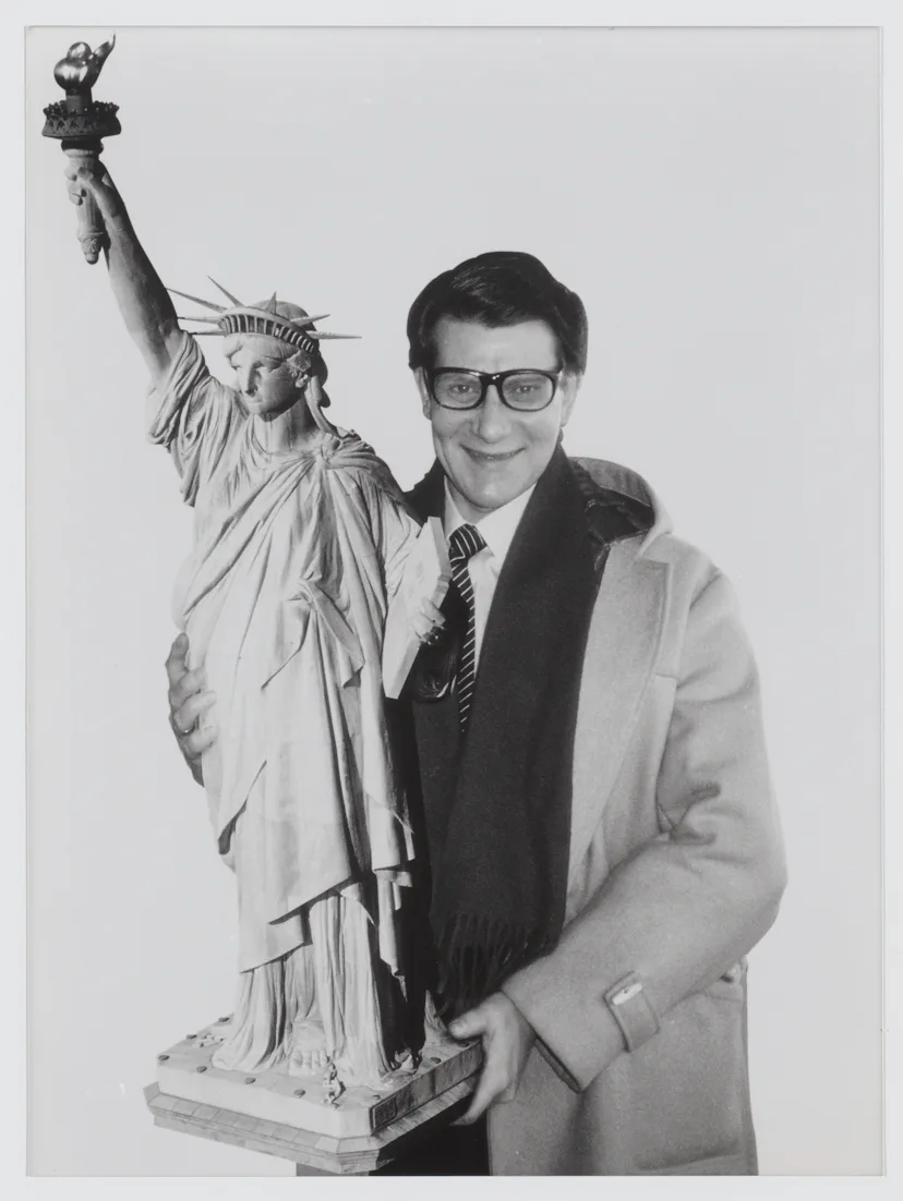 Yves Saint Laurent carrying a reproduction of the Statue of Liberty, New York, 1983