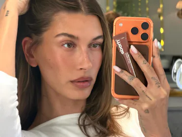 Hailey Bieber taking a mirror selfie, her hand in her hair