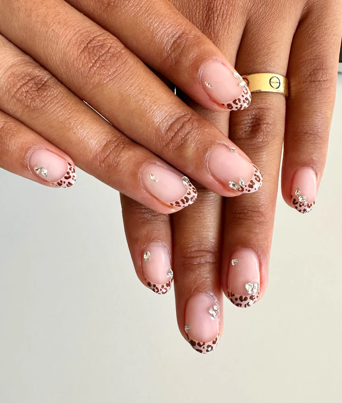 Olivia Dean's hands with a leopard print French manicure