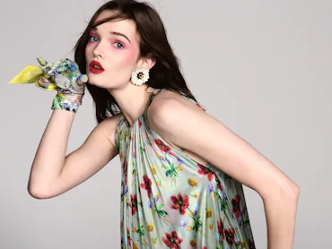 a model wearing a floral dress with pink flush makeup and pink lips