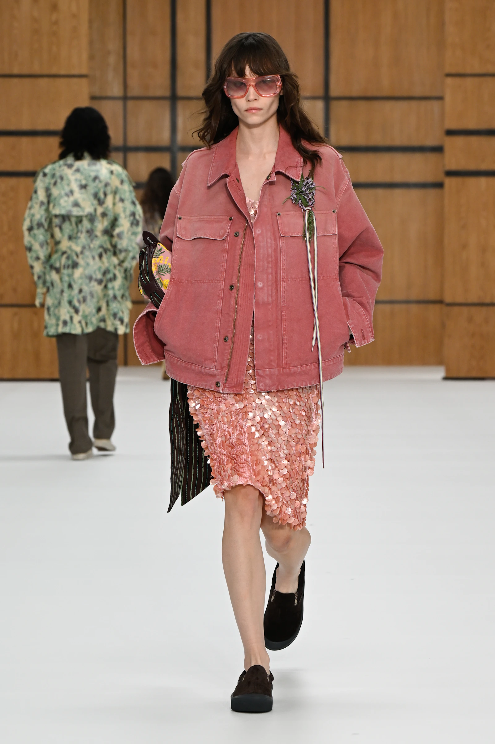 Model in a washed pink Burberry denim jacket over a pink sequined skirt