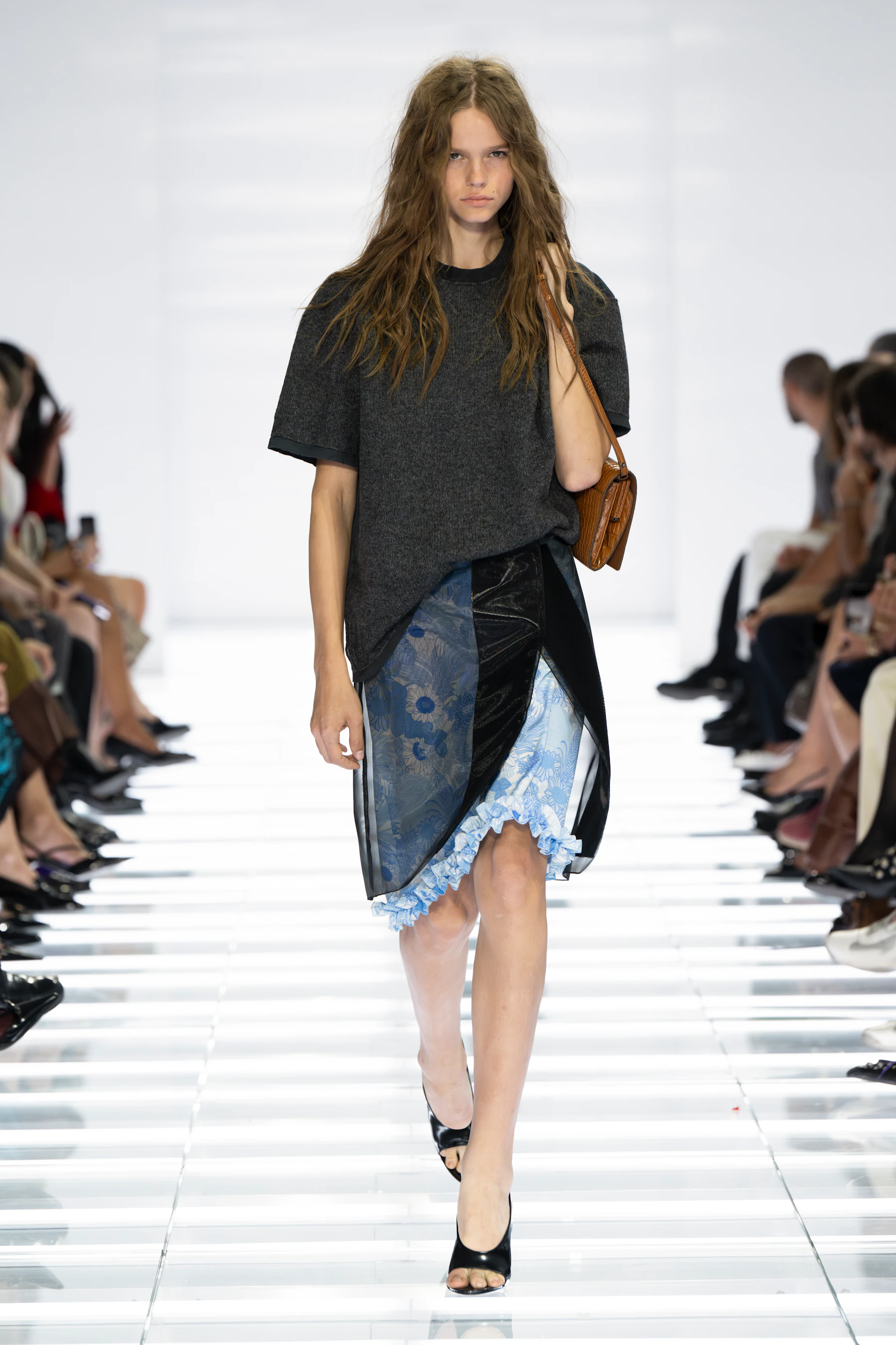 Model in a dark Prada T-shirt and asymmetrical black and blue painted skirt