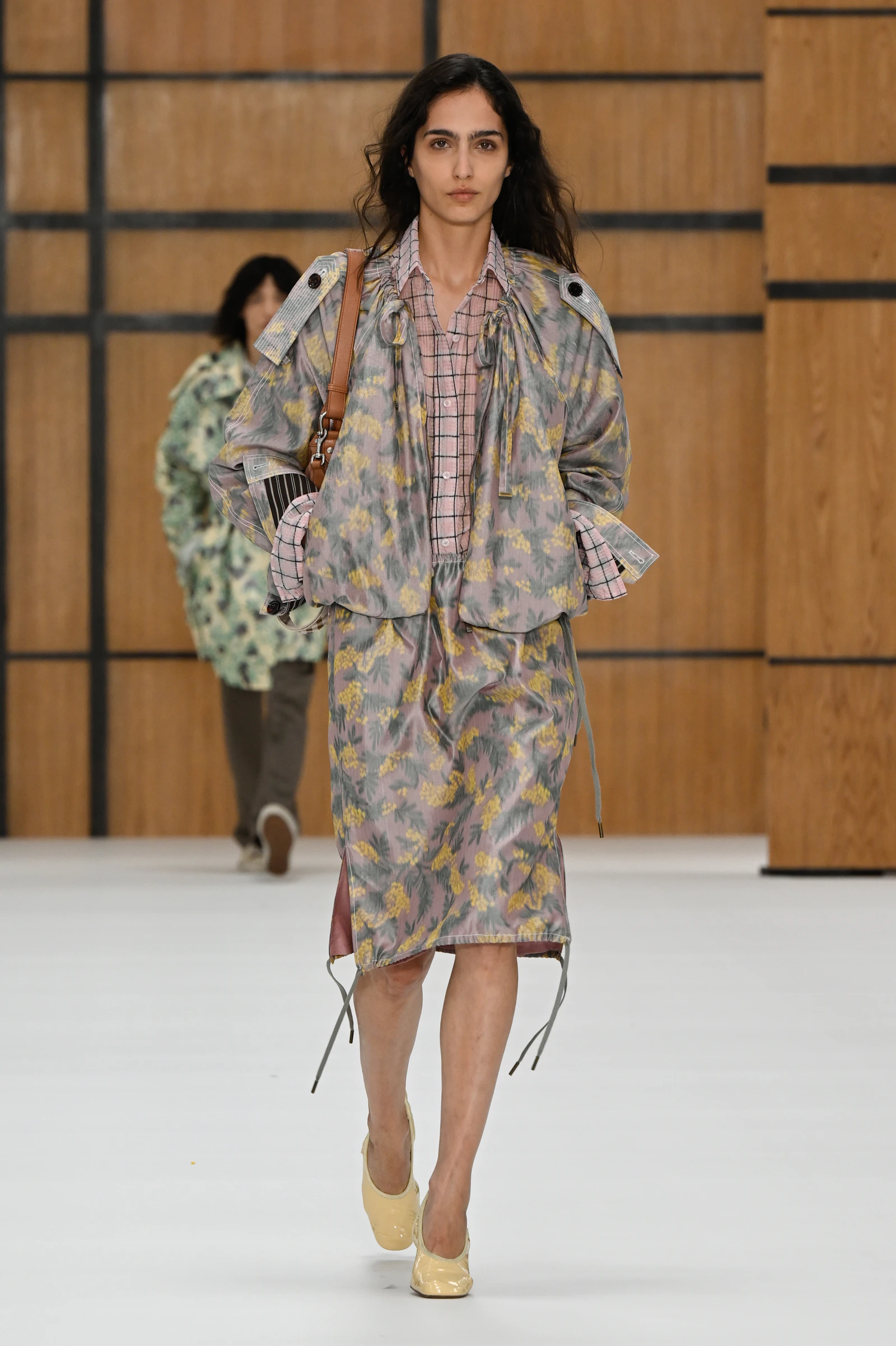Model in a pale washed floral Burberry jacket and skirt layered over a checked shirt
