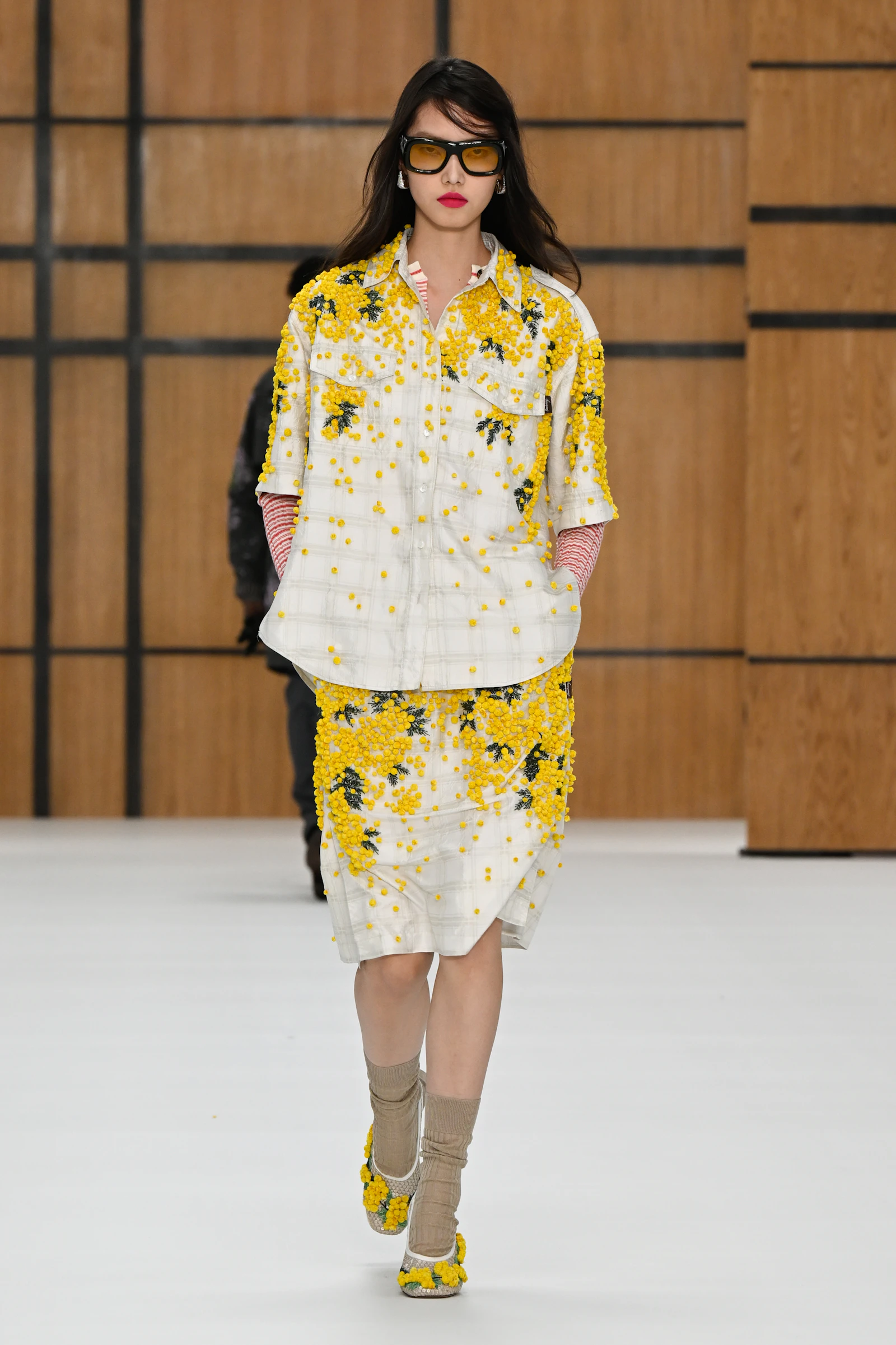 Model in a white and yellow Burberry shirt and skirt covered with floral embroidery