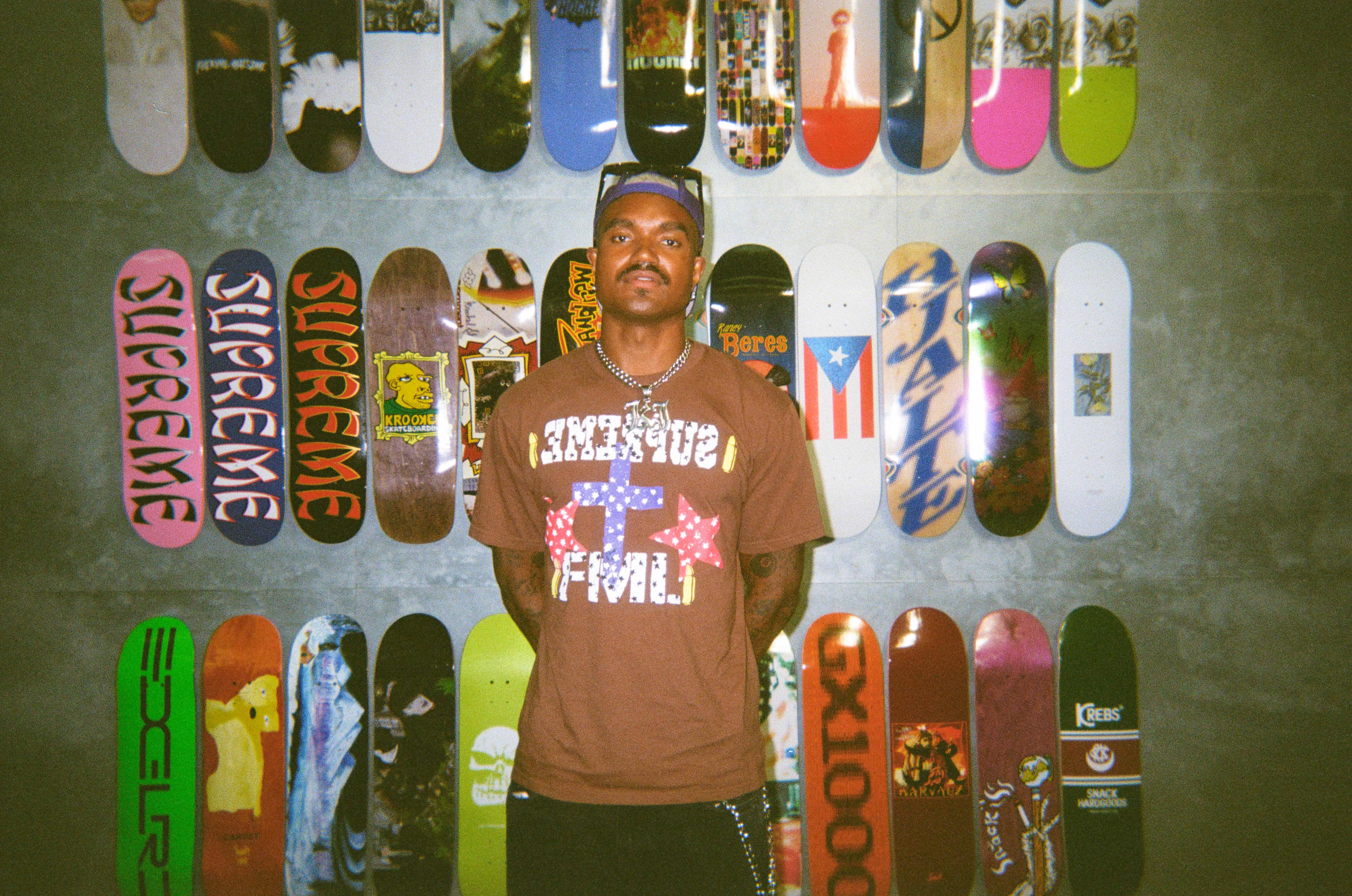 'Summer House' star KJ Dillard posing in front of skateboards.