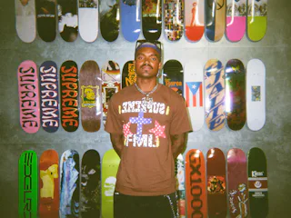 'Summer House' star KJ Dillard posing in front of skateboards.