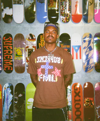 'Summer House' star KJ Dillard posing in front of skateboards.