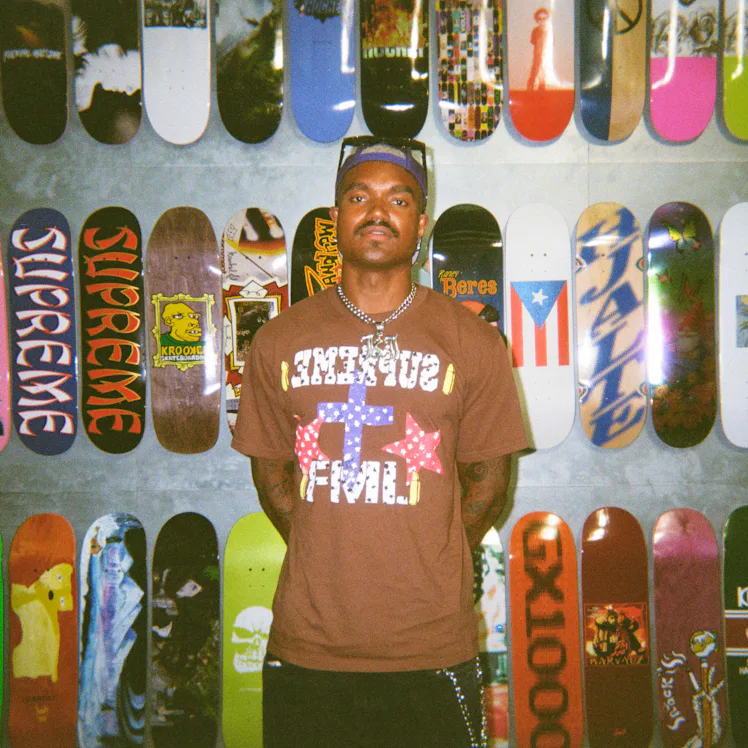 'Summer House' star KJ Dillard posing in front of skateboards.