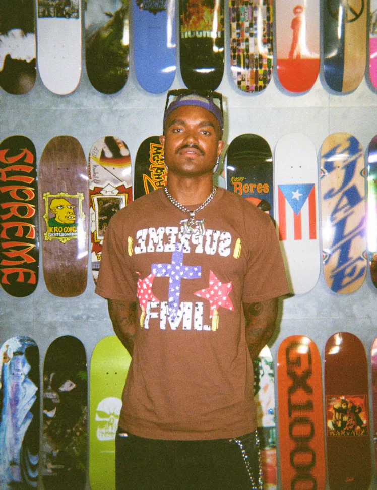 'Summer House' star KJ Dillard posing in front of skateboards.