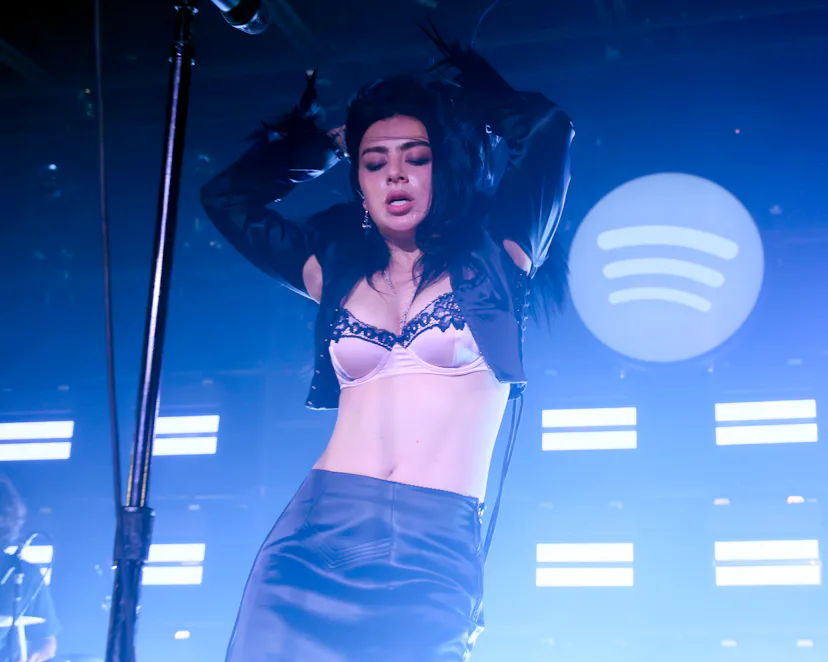 Charli xcx performing in a bra at her concert.