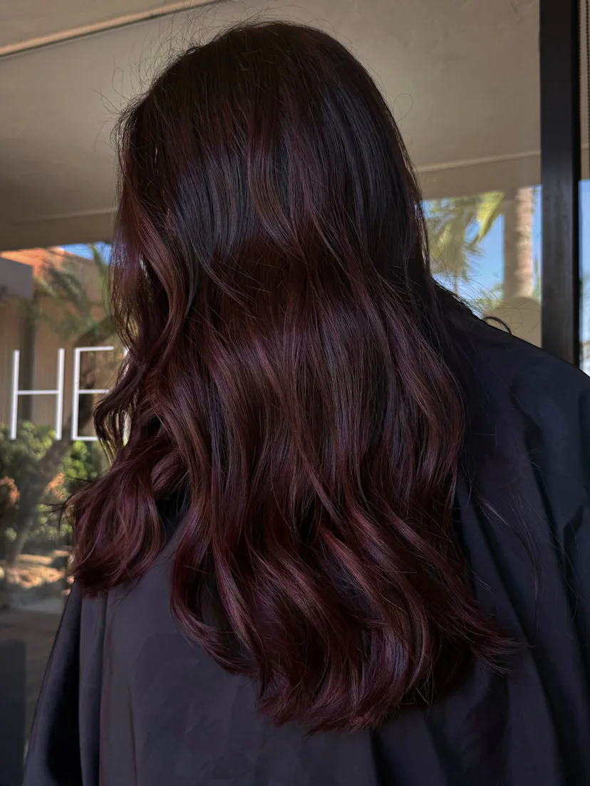 Close up of a woman's cherry cola, purple-tinged wine red hair