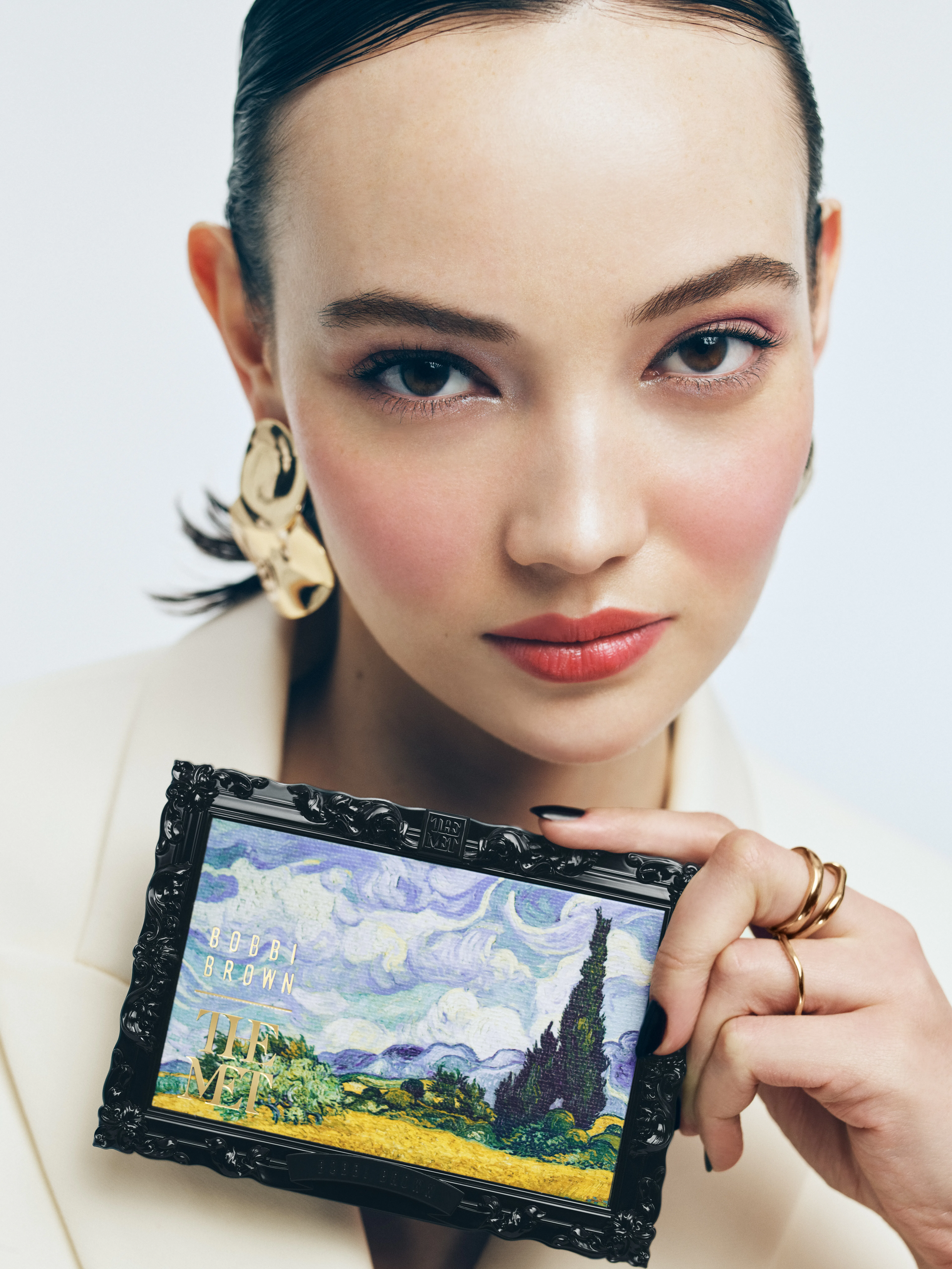 A model holding an eyeshadow palette from the Bobbi Brown x The Met collection