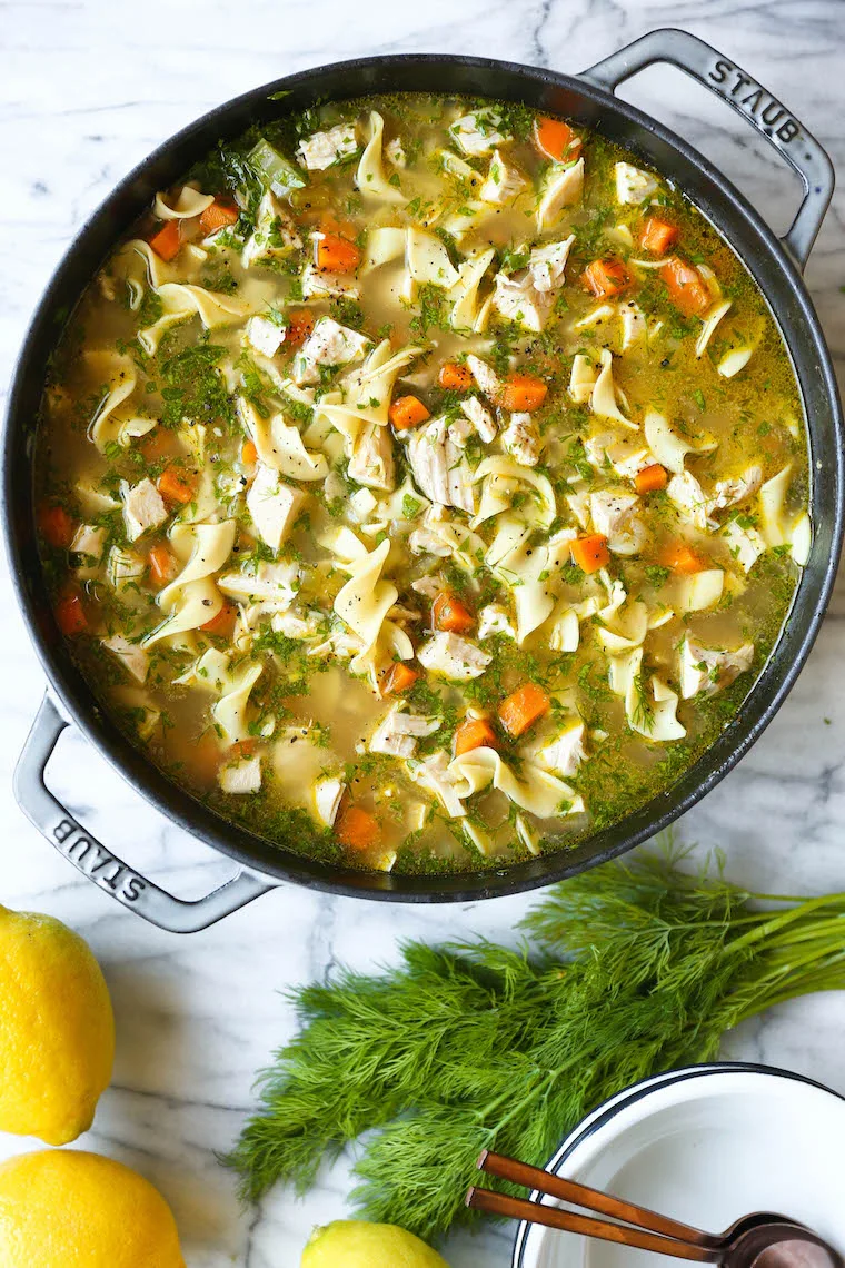 homemade chicken noodle soup in a staub pot, in a story about easy recipes for when you're sick
