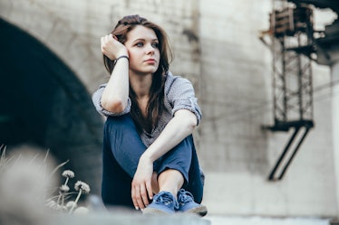 Outdoors portrait of beautiful young sad teen girl sitting on stairs