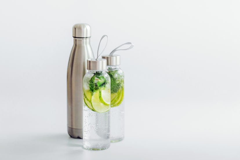Fresh lime and mint infused water, cocktail, detox drink, lemonade in reusable bottles. Summer drink...