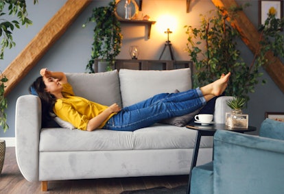 Young brunette woman relaxing on the couch after a long day. Cozy home concept