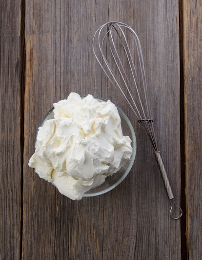 Preparation of whipped cream with a hand mixer metal on a wooden background. Top view. Mascarpone.