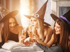 In good moods at halloween party. womans lying and drink champagne