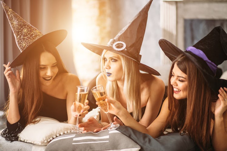 In good moods at halloween party. womans lying and drink champagne