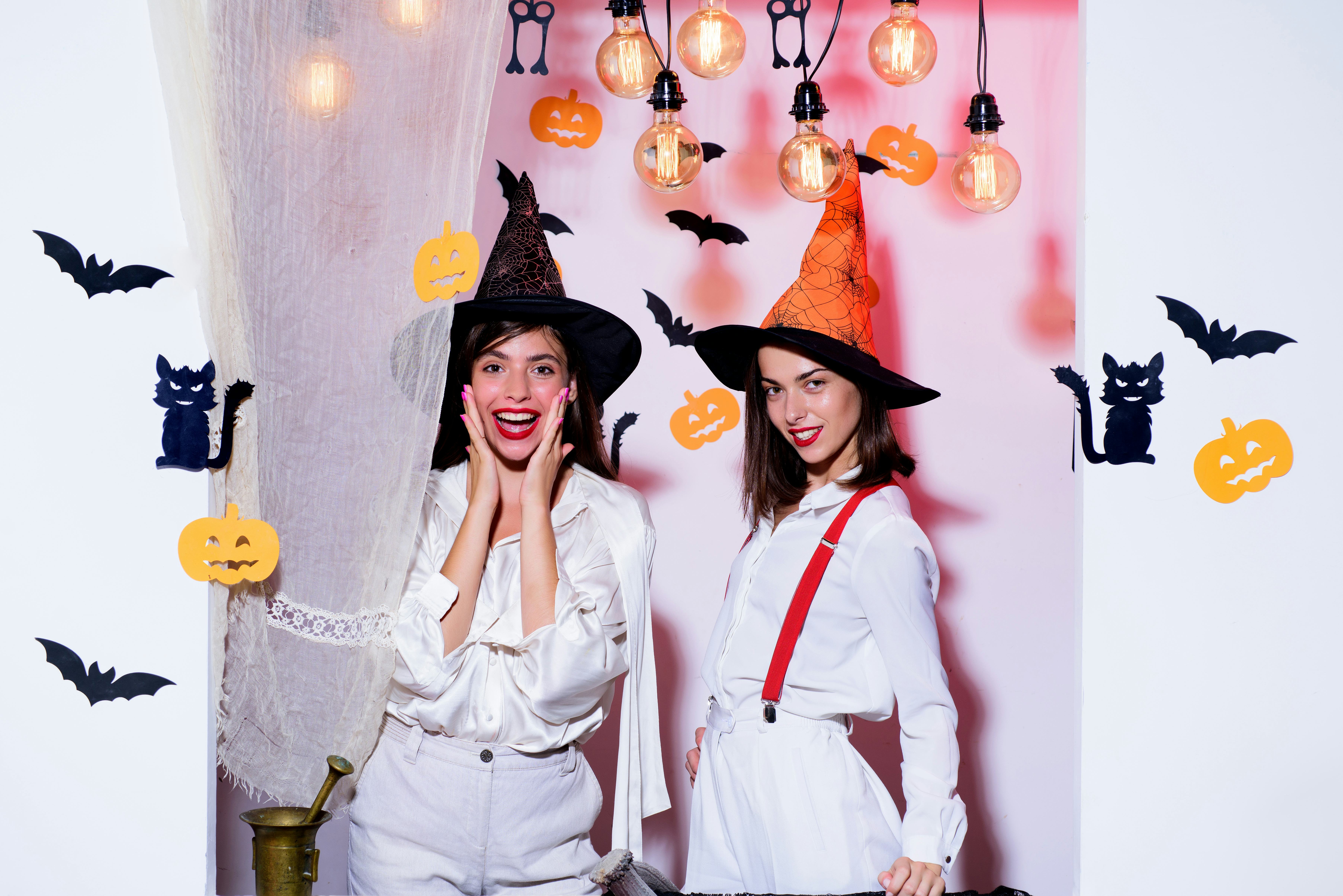 Emotional young women in halloween costumes on halloween party. Surprise. Halloween girls through ho...