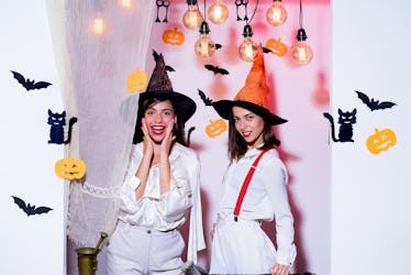 Emotional young women in halloween costumes on halloween party. Surprise. Halloween girls through ho...