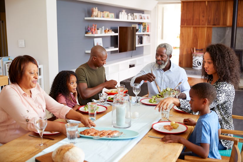 Multi-Generation Family Sitting Around Table At Home Enjoying Meal Together. If there's tension at t...