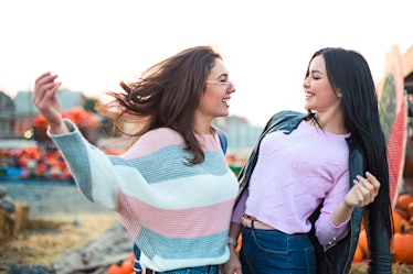 Instagram captions for pumpkin patch photos are perfect for these two young women laughing and looki...