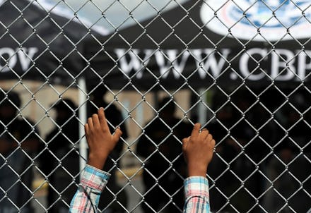 A migrant leans on a fence of the Gateway International Bridge that connects downtown Matamoros, Mex...