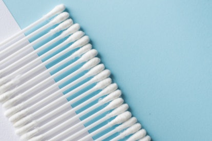 Selective focus of white cotton buds or cotton swab on blue background. copy space