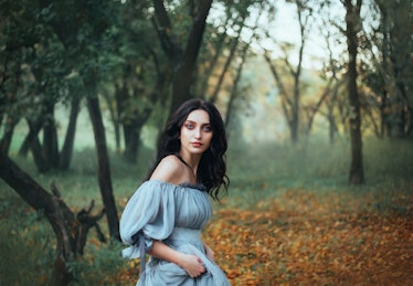 mythical story about woman Pandora, lady with tar black hair and blue eyes, forest beauty in gray dr...