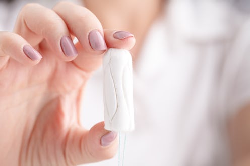 woman holding a tampon