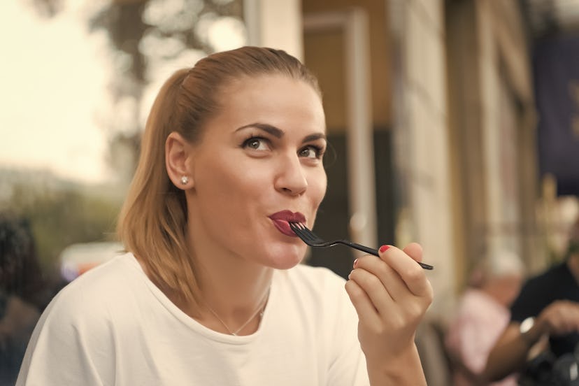 Happy woman eat with fork in restaurant in paris, france. Hunger, appetite concept. Food, snack, eat...