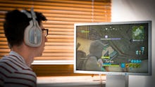 Teenager playing Fortnite video game, Fortnite is a web based multi player survival game developed b...